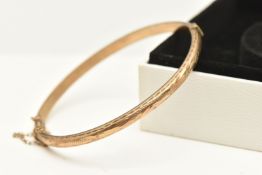 A 9CT GOLD HINGED BANGLE, textured pattern, fitted with a sliding clasp and additional safety chain,