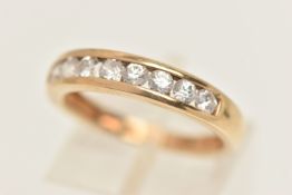 A 9CT GOLD GEM SET RING, yellow gold band ring channel set with circular cut cubic zirconia,