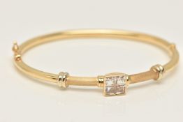 YELLOW METAL HINGED BANGLE, a hollow bangle with a high polish and matt finish, centrally set with