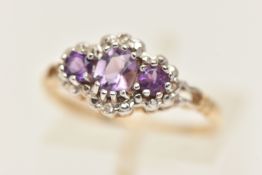 A 9CT GOLD GEM SET RING, designed as three circular cut amethysts, prong set in white gold with four