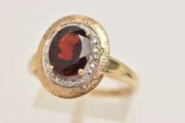 A 9CT GOLD GEM SET RING, principally set with an oval cut garnet, prong set in yellow gold, set with