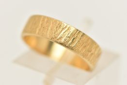 AN 18CT GOLD BAND RING, a flat profile band ring with textured bark detail, approximate band width