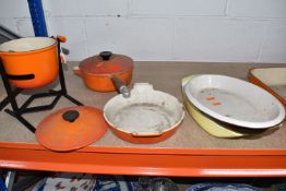 A GROUP OF ENAMELLED CAST IRON COOK WARE, comprising an orange Le Creuset fondue pot and stand, with