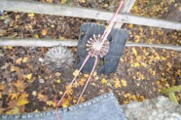 A PINK METAL SCULPTURE OF A FLAMINGO, two wooden mask plaques and a sunburst plaque, condition