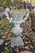 A WEATHERED CONCRETE CAMPAGNA GARDEN URN, with twin handles on an odd loose plinth, width between