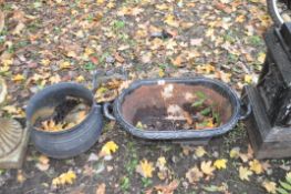AN EARLY 20th CENTURY CAST IRON OVAL PLANTER in the form of a small bath 69cm long, a modern