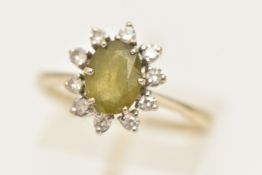 AN 18CT WHITE GOLD CLUSTER RING, of an oval form, set with a central oval cut peridot in a