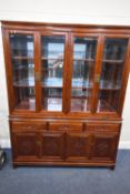 A MODERN ORIENTAL STYLE HUANGHUALI DISPLAY CABINET, the four glazed doors enclosing glass shelves,