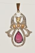 A GEM SET PENDANT, a white metal pendant principally set with a carved pear shape garnet, three