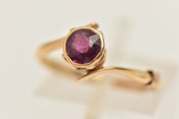 AN EARLY 20TH CENTURY 18CT GOLD GARNET RING, collet set with a circular cut garnet, cross over