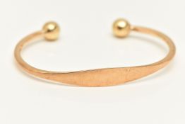 A YELLOW METAL CUFF BANGLE, polished design with two ball terminals, stamped 9kt, approximate