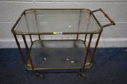 IN THE MANNER OF MAISON JANSEN, A MID-CENTURY TROLLEY, with two glass inserts, raised on faux bamboo