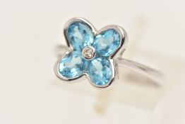 A CONTEMPORARY 9CT GOLD GEM SET RING, designed as a flower set with blue topaz and a central round