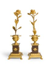 A pair of Empire ormolu and patinated bronze candlesticks, early 19th century, each in the form o...
