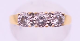 An 18 ct gold three stone diamond ring. Ring size K.