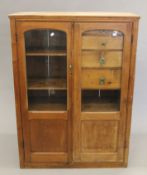 A Victorian pine two-door cabinet. 127 cm high x 94 cm wide x 35 cm deep.