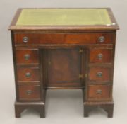 A mahogany kneehole desk. 75.5 cm wide.