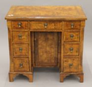 An early 20th century walnut kneehole desk. 74 cm high x 79 cm wide x 44 cm deep.