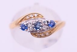A 9 ct gold, diamond and sapphire crossover ring. Ring size O.