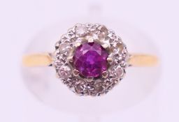 An 18 ct gold, ruby and diamond flower head ring. Ring size J.