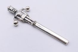 A sterling silver soldier rattle. 13 cm high.