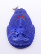 A seated deity pendant. 6 cm high.