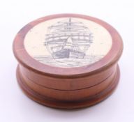A circular wooden and bone cased compass, the lid decorated with a ship. 6.5 cm diameter.
