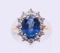 An 18 ct gold, diamond and blue stone ring. Ring size J.