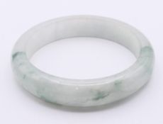 A celadon jade bangle. 5.75 cm internal diameter, 0.75 cm wide.