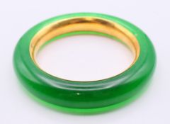 A jade and gilt-lined bangle. 6 cm internal diameter, 9 cm external diameter, 1.5 cm wide.
