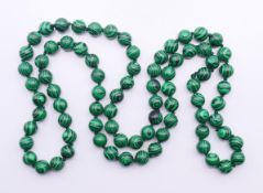 A string of malachite beads. 86 cm long.