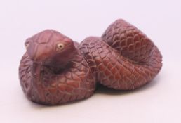 A wooden snake netsuke. 5 cm long.