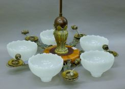 An early 20th century walnut and brass five-branch hanging light. 59 cm high.