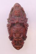 A wooden praying deity netsuke. 7 cm high.