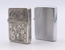 A vintage sterling silver-cased Zippo lighter with engraved floral design and a vintage Zippo