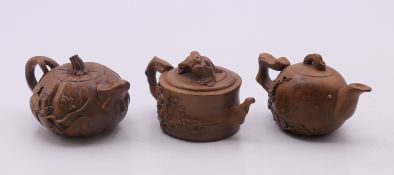 Three Chinese wooden miniature teapots. Each approximately 4.5 cm high.