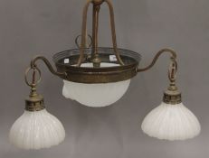 A brass and opaline glass hanging light fitting. 55 cm high. Ceiling fitting 11 cm diameter.