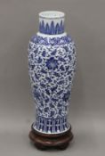 A large 18th/19th century Chinese blue and white porcelain vase on a carved wooden stand.