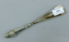 A silver-handled shoehorn. 22 cm long.