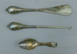 A silver caddy spoon and a silver-handled button hook and shoe horn. The former 10.5 cm long.