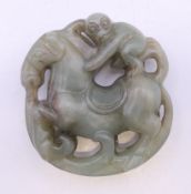 A jade roundel of a monkey riding a horse. 5 cm diameter.