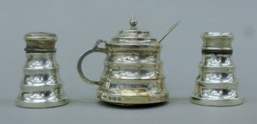 A three-piece silver cruet set. The mustard pot 6 cm high. 107.7 grammes loaded.