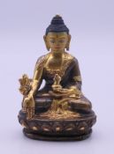 A Tibetan gilded and painted copper seated Buddha. 8 cm high.