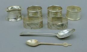 Six silver napkin rings and two silver teaspoons. The larger spoon 12 cm long. 116.8 grammes.