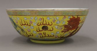 A Chinese yellow ground porcelain bowl decorated with five-clawed dragons and a phoenix.