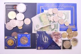 A collection of commemorative coins and notes in a vintage metal cash box with handle.