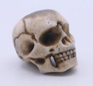 A stag's horn model of a skull. 3 cm high.