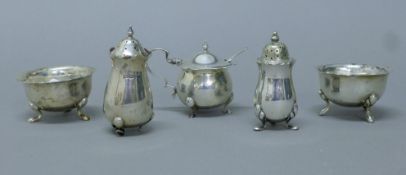 A four-piece silver cruet set and a silver plated pepper. The mustard pot 5.5 cm high. 155.