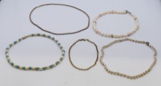 A pearl necklace with 9 ct gold clasp, two chains and two other necklaces.