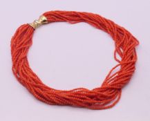 An eighteen strand twisted coral bead necklace with an 18 ct gold clasp. 46 cm long.